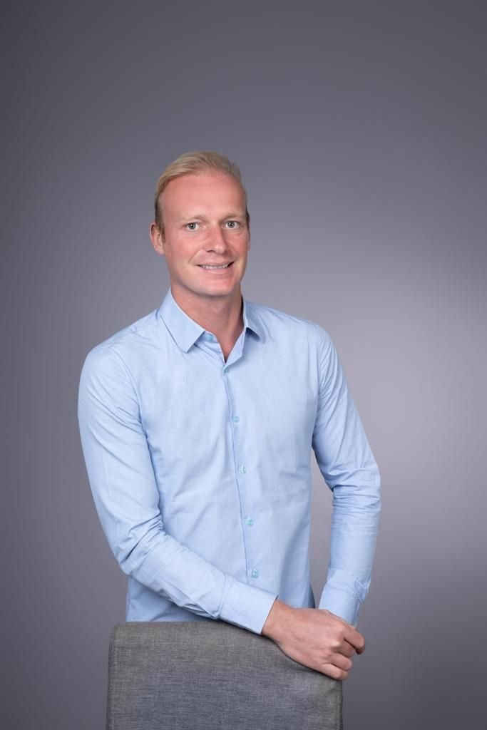 A smiling man in a blue shirt