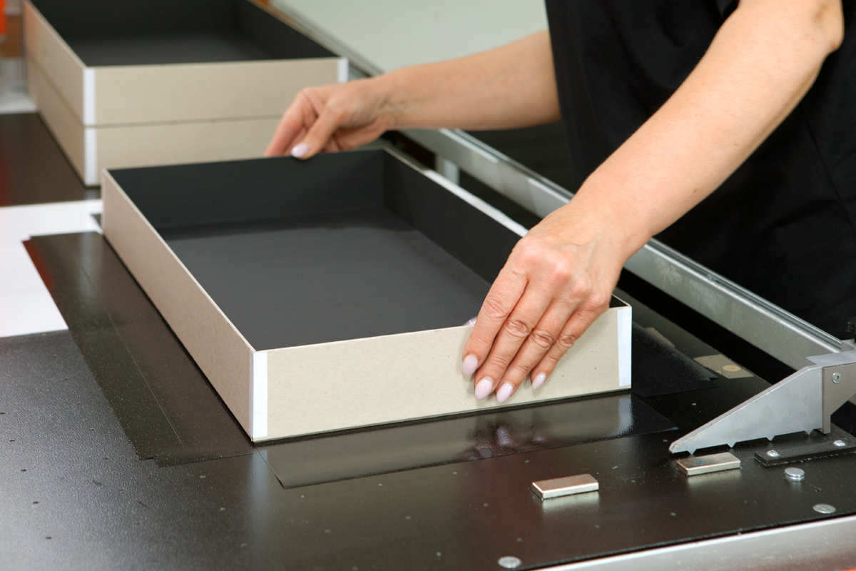 A person's hands assembling a cardboard box
