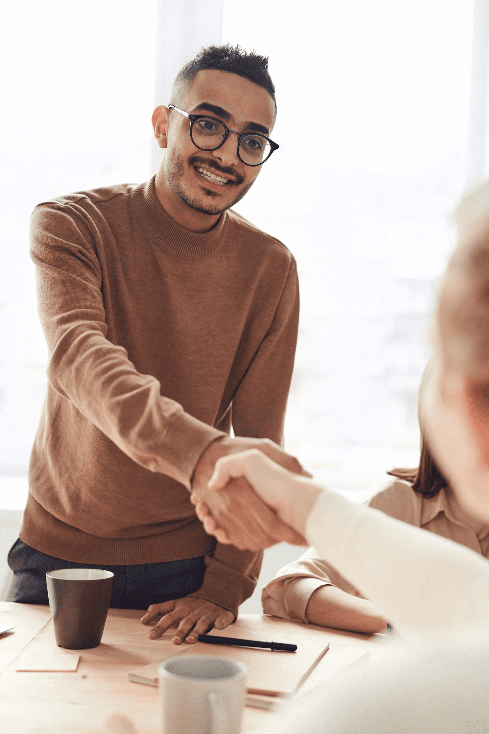 Man in glasses smiling, shaking hands